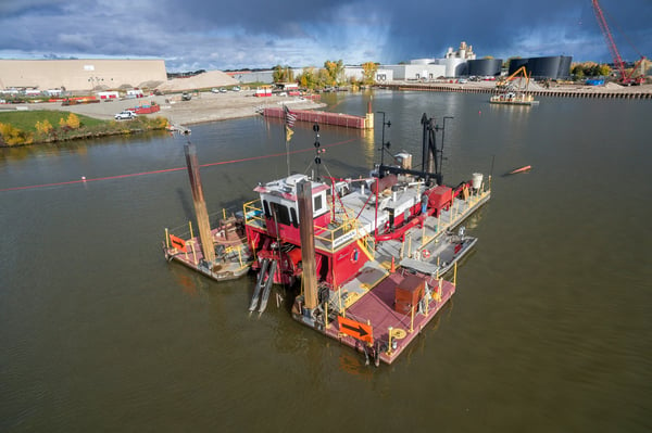 A dredge operator sits in the lever room with tools that help provide critical information.