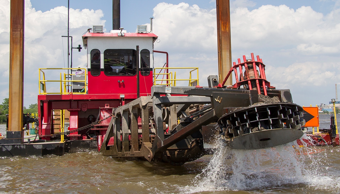 A dredge operator uses equipment to excavate and maintain waterways.